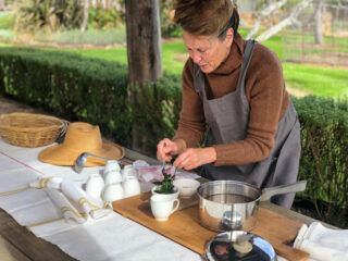 A woman prepares soup in cups